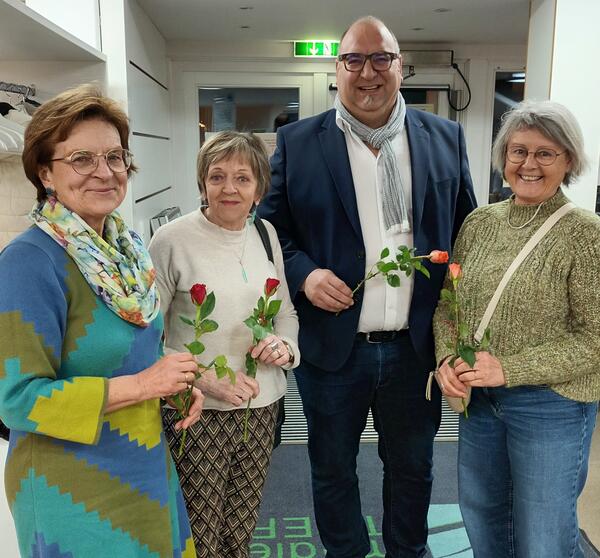 Bürgermeister Klaus Schejna verschenkt faire Rosen an Besucherinnen der Veranstaltung "Wir Frauen" im Rodenbacher Medientreff. 